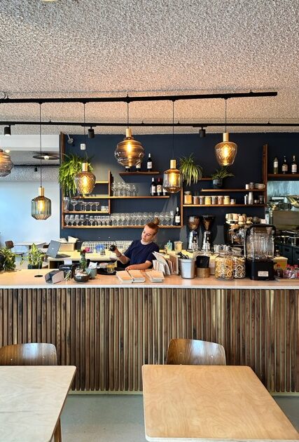 Iemand achter de bar in een restaurant schenkt iets in