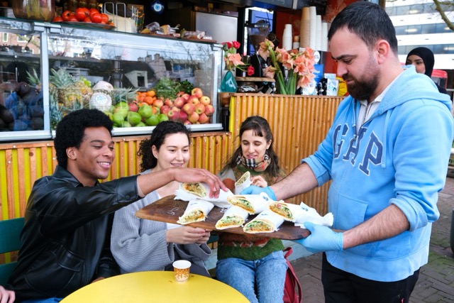 Someone hands out falafel to people participating in a team outing in Amsterdam