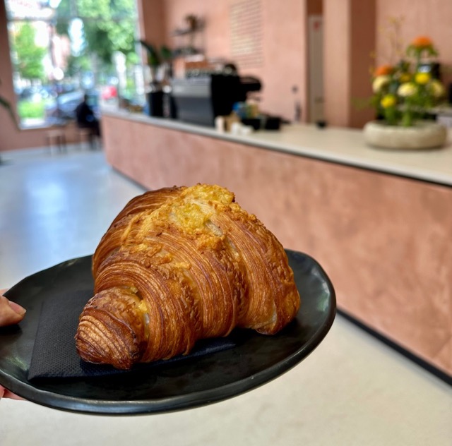 Iemand houdt een vegan croissant vast