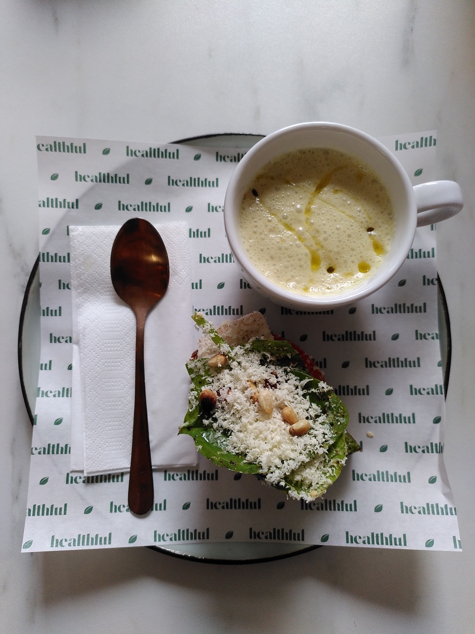 Van boven een kopje soep met een belegd broodje. Links ervan ligt een lepel